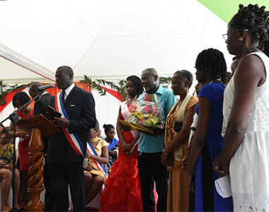 Monsieur Sorel CHELEUX avec la composition florale à la main a été décoré durant la cérémonie protocolaire de la Fête Patronale 2015 de Morne-à-l’Eau